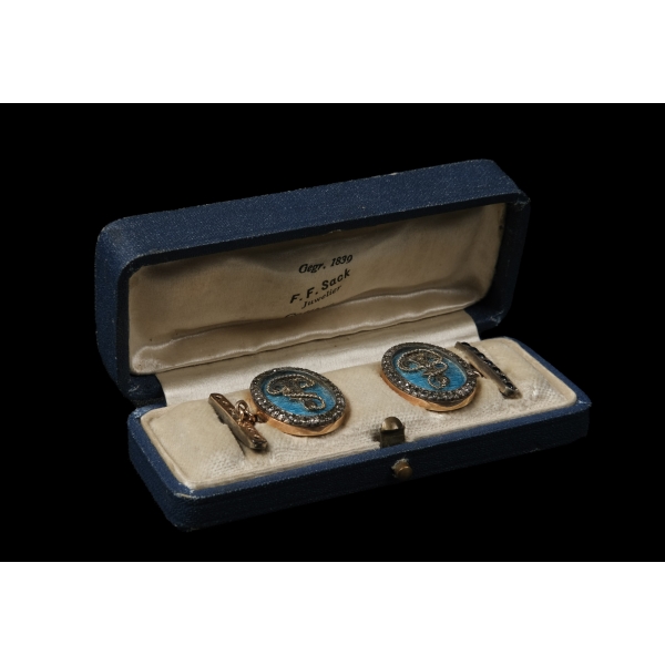 F. F. Sack Juwelier Cottbus marka, mine ve değerli taş işçilikli, çapa figürlü gümüş kol düğmesi, orijinal kutusunda... Kol düğmesi 2x2 cm, kutu 9x3,5x2,5 cm...
