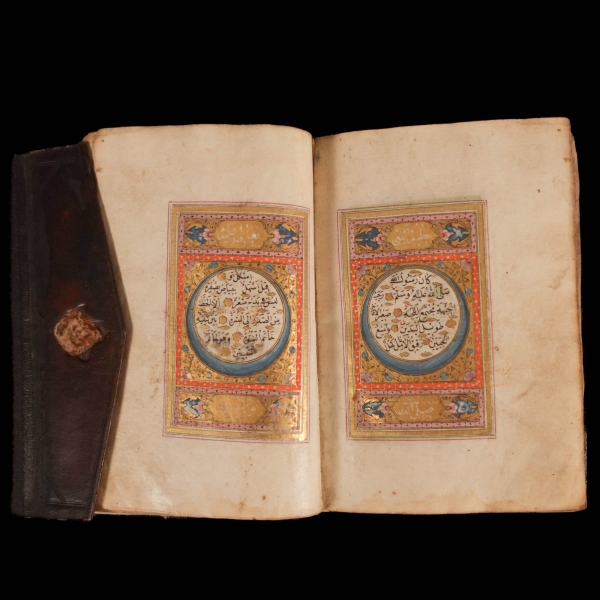 ENAM-I ŞERİF (Sureler, esma-i hüsna, esma-i nebi, hilye-i nebi, dualar), ketebe: Hasan Vehbi Efendi talebesi Seyyid Ahmed Nazifi, 1225, serlevhalı, tüm sayfaları tahrirli altın cetvelli, sure başları altın levhalı, ketebe sayfası tezyinatlı, şemseli köşebentli deri dönem cildinde, 172 sayfa, 14x9 cm...